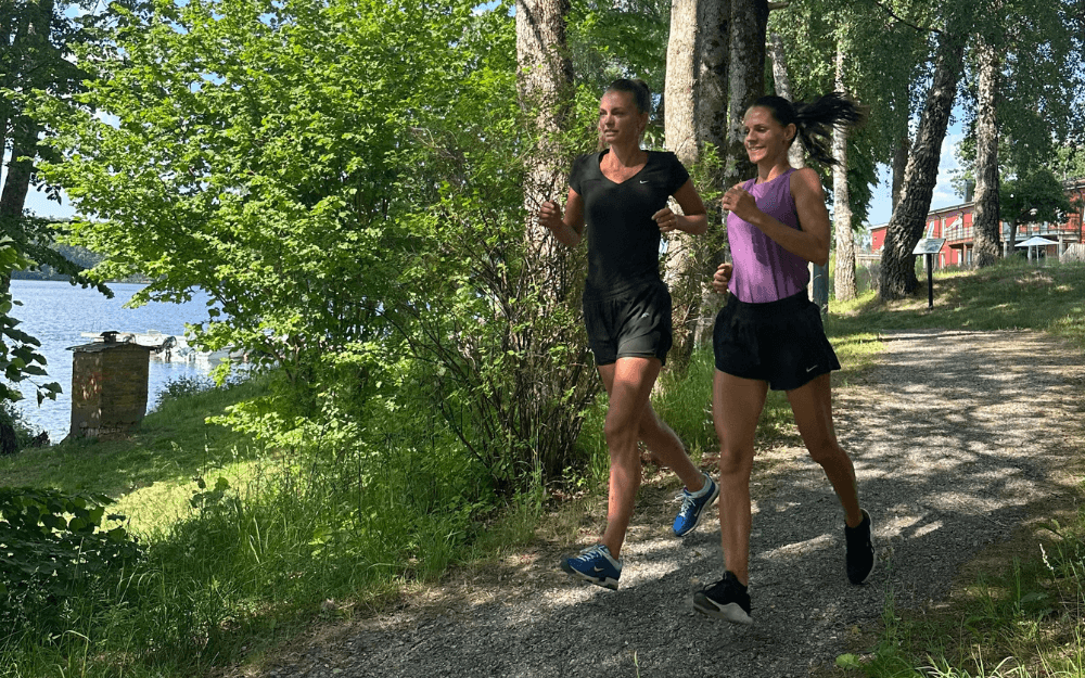Två kvinnor springer på en promenadstig.