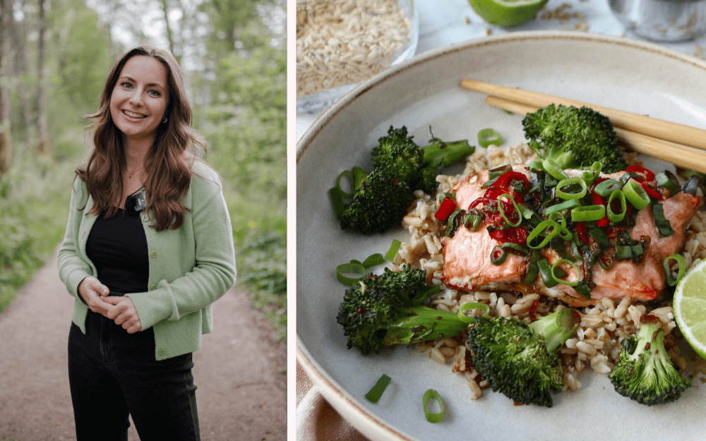 Leende, mörkhårig kvinna med ljusgrön kofta står på en stig i skogen. Vit tallrik med lax, broccoli, matvete, chili, lime och ätpinnar.