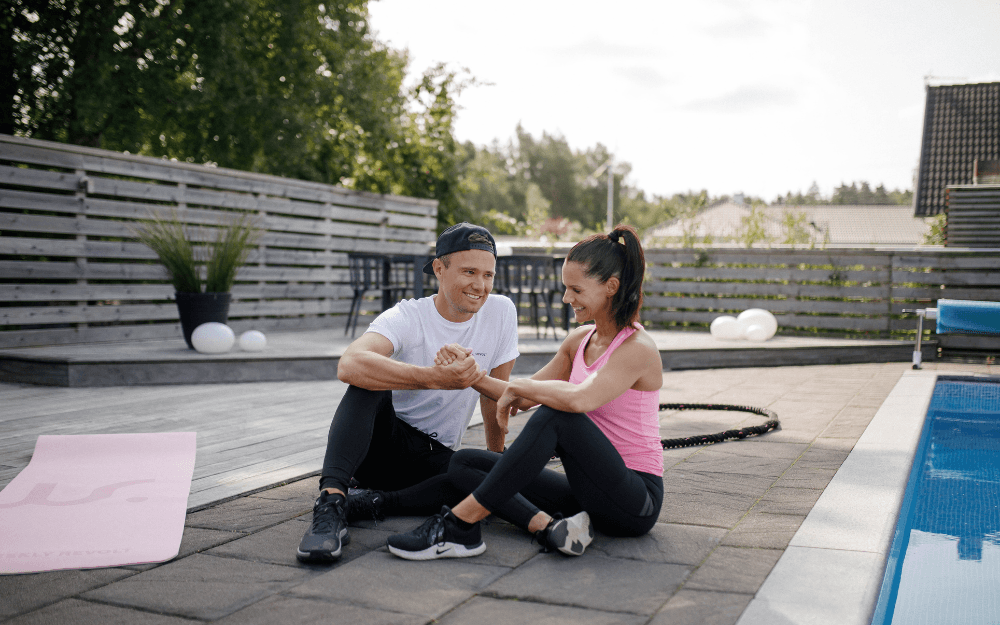 Jonathan Hoel och Louise Åberg sitter på sin altan bredvid poolen.