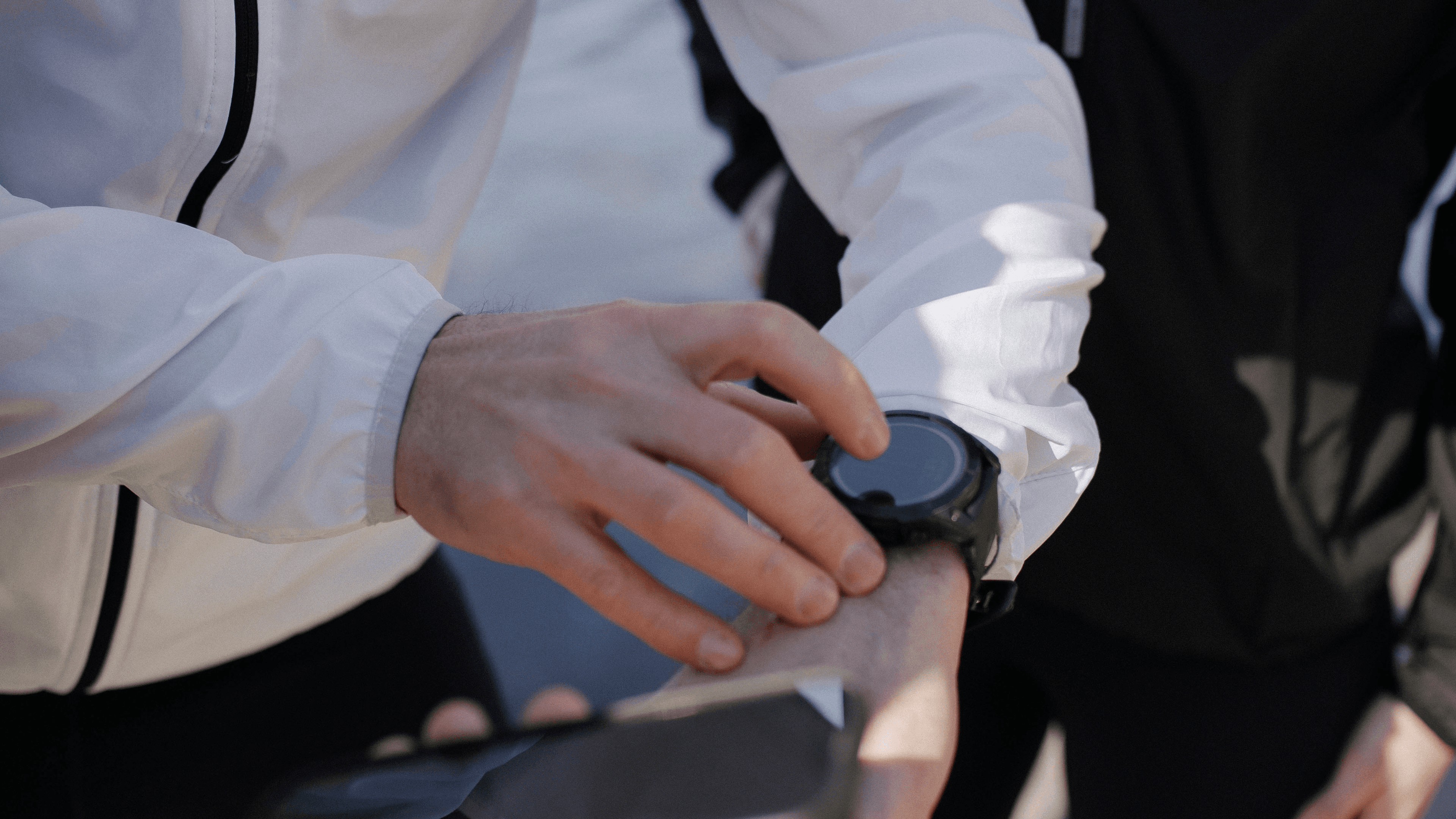 Närbild på hand som trycker på sportklocka.