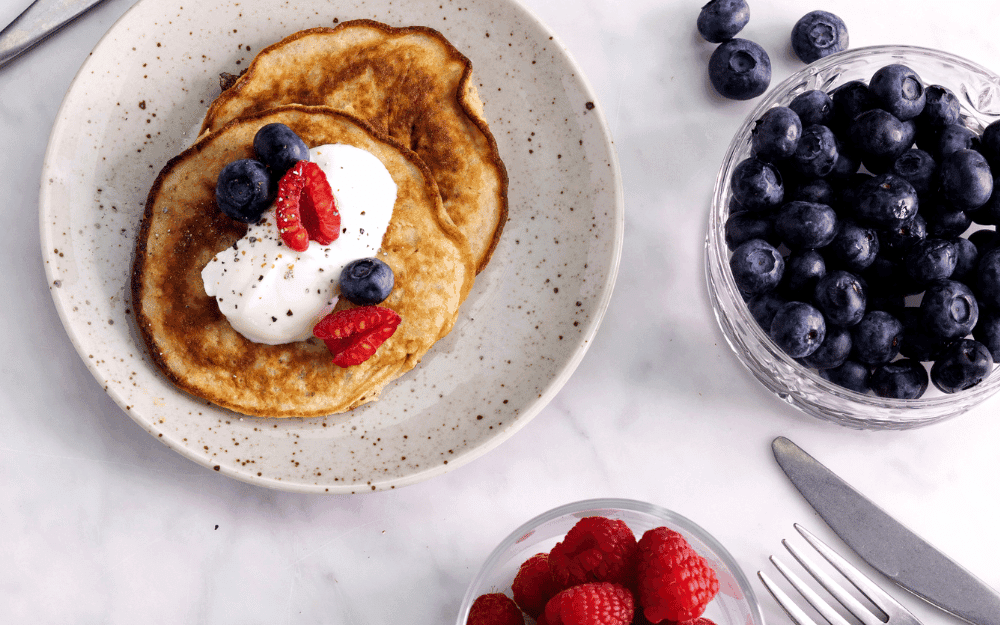 Bananpannkakor toppade med färska hallon och blåbär samt en klick grekisk yoghurt.