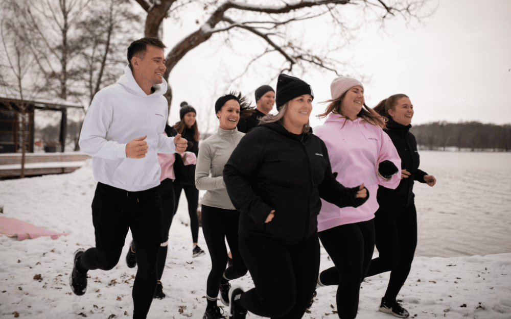 Flera personer som joggar tillsammans i snön.