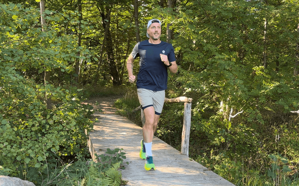 Löpcoach Micke springer i skogen.