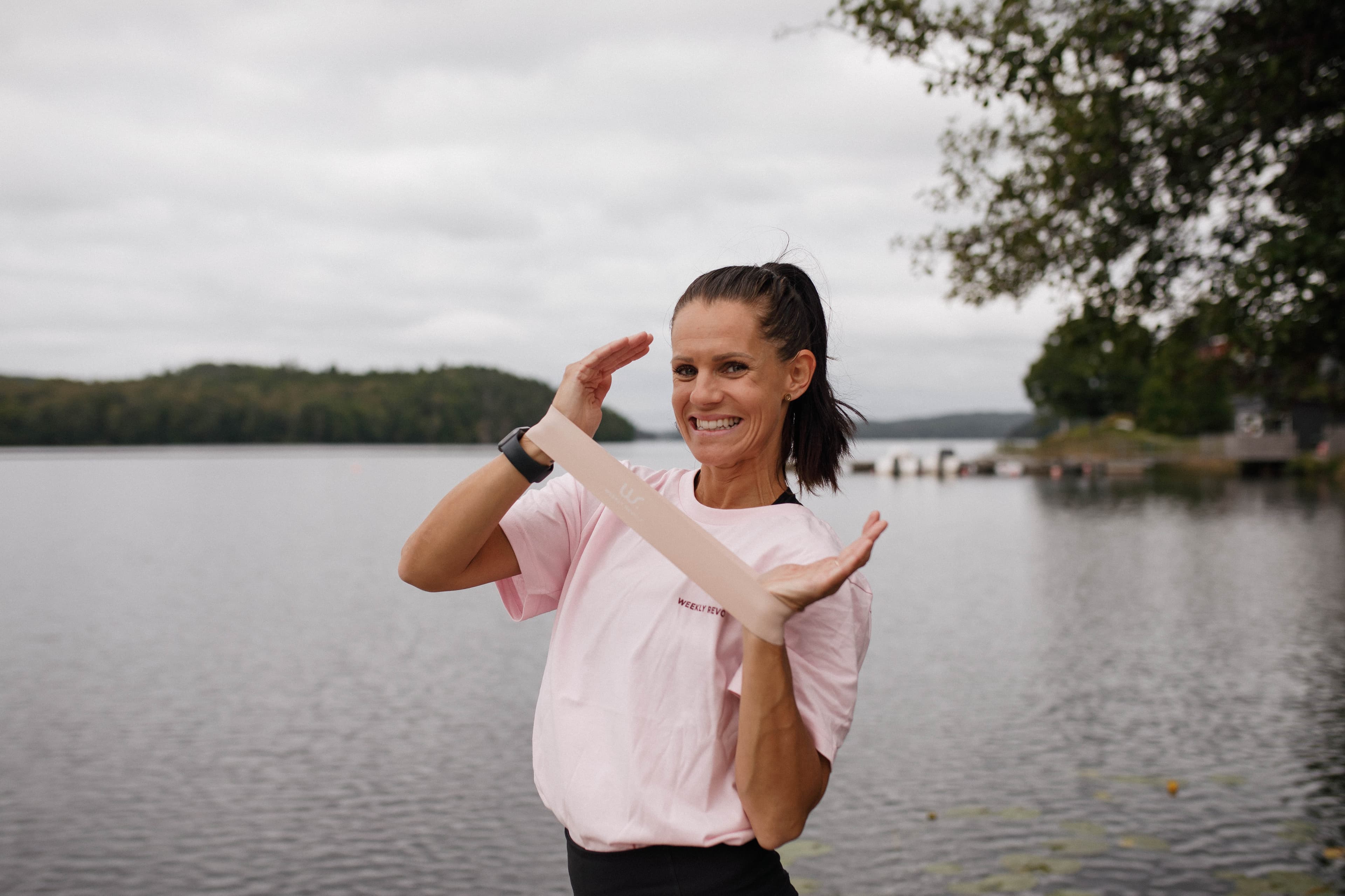 Kvinna håller i rosa träningsband.