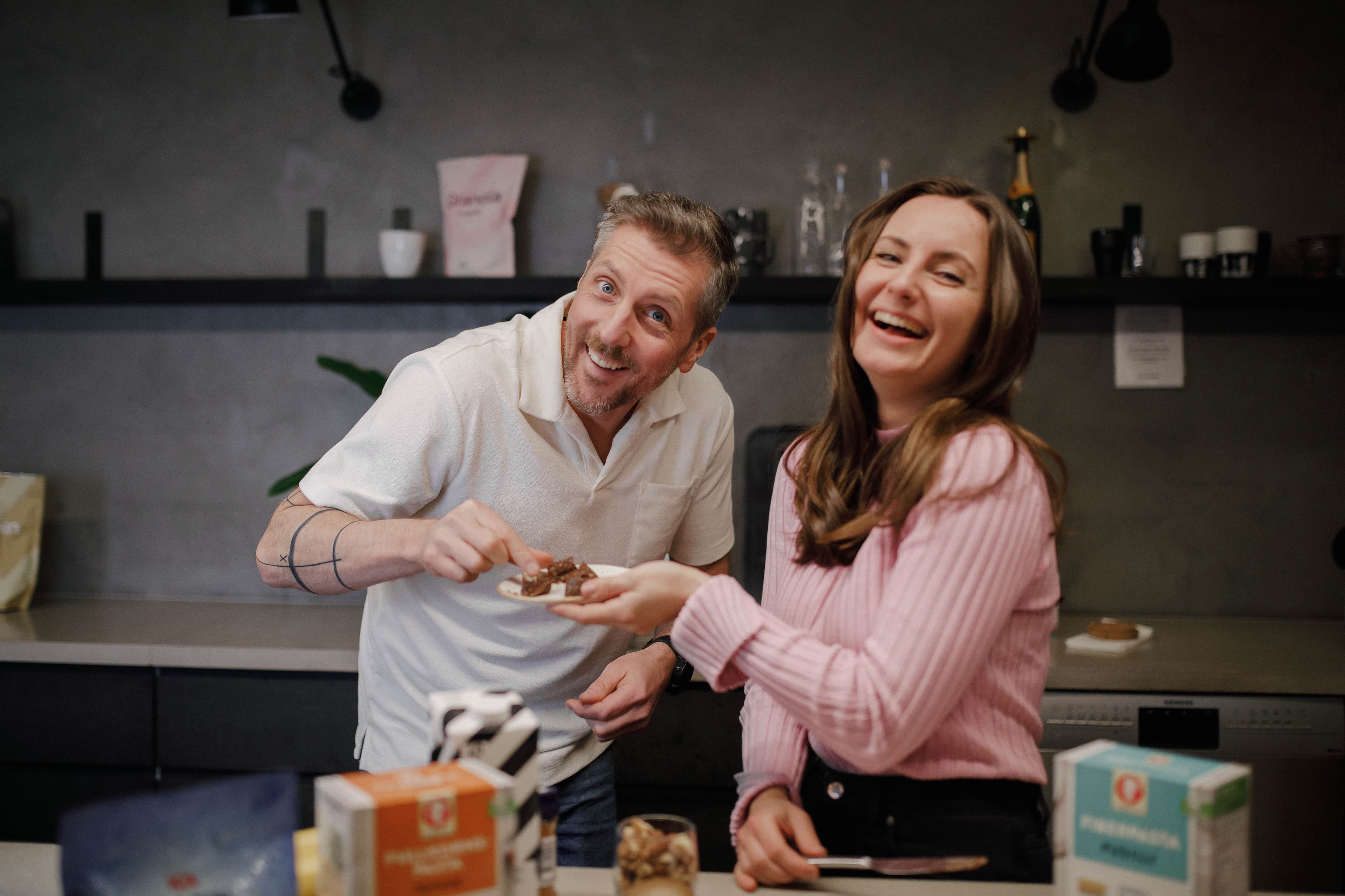 Löpcoach Micke och dietist Joanna Ostrowska skrattar i köket.