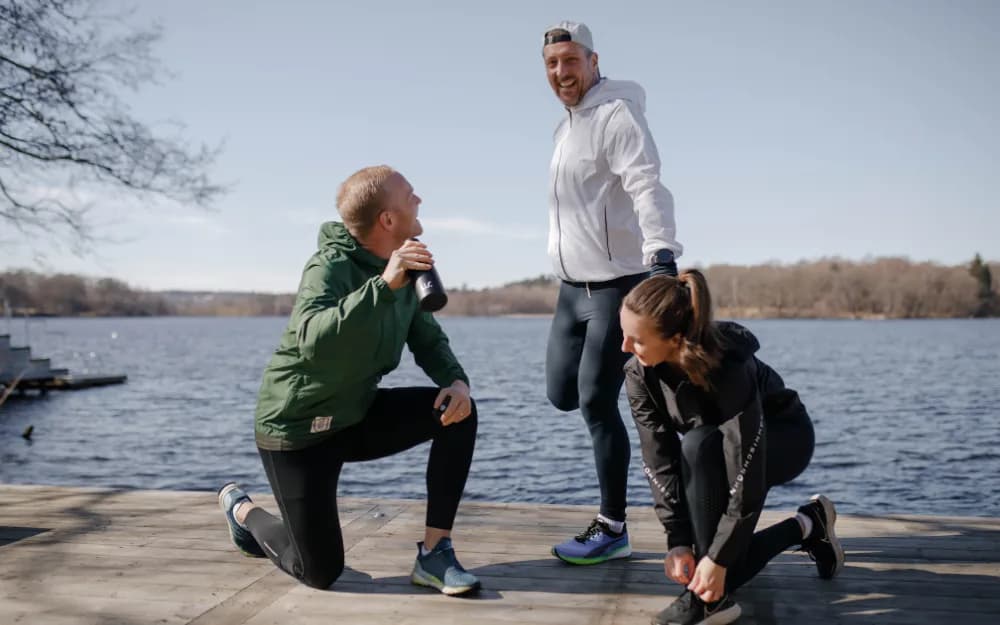 Tre personer som stretchar på en brygga