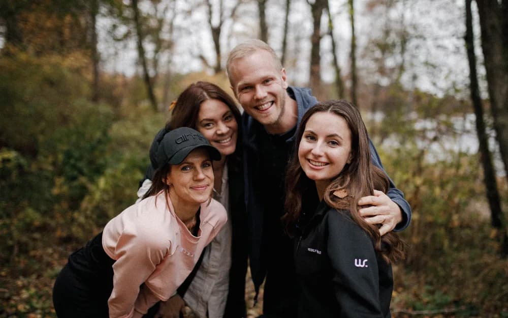 Fyra personer i en skog som ler mot kameran.