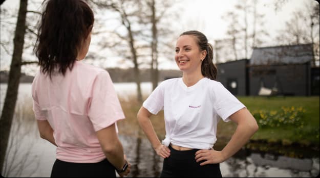 Två medlemmar från weekly revolts team pratar och skrattar med varandra